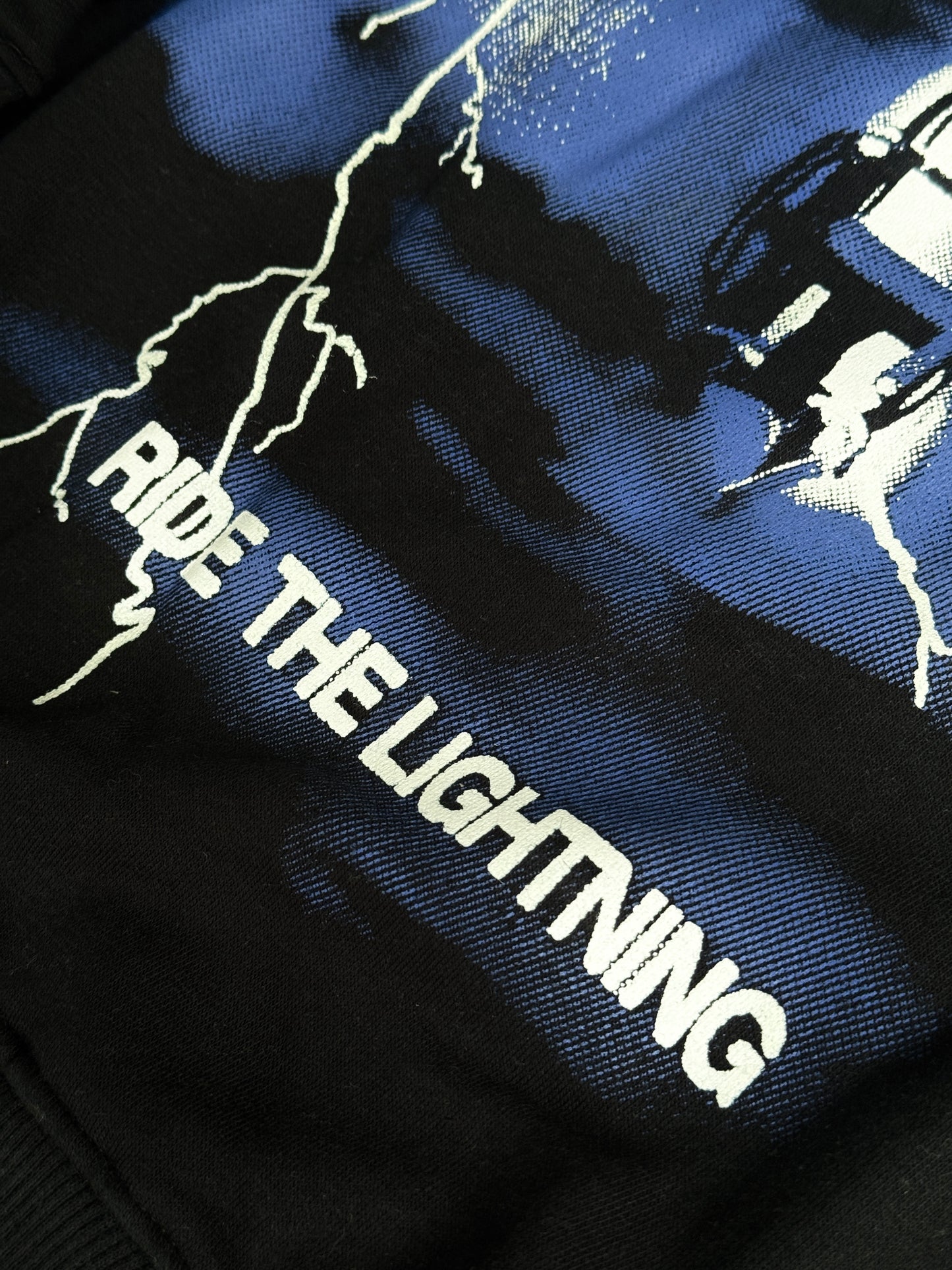 Black hoodie with 'Ride the Lightning' text and graphic design on a dark background